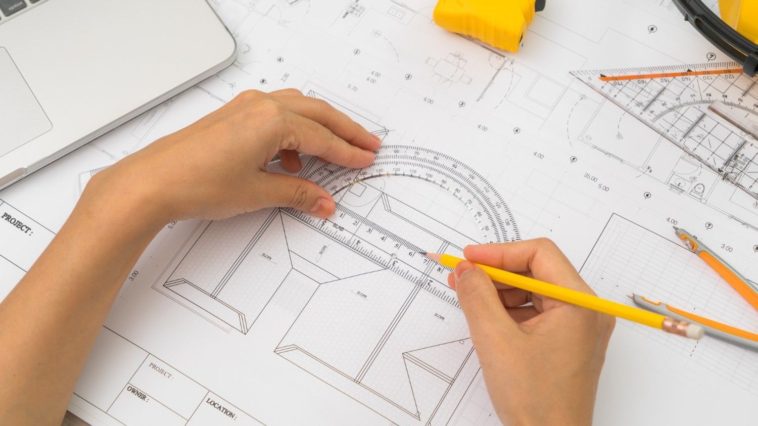hand-construction-plans-with-yellow-helmet-drawing-tool (1)